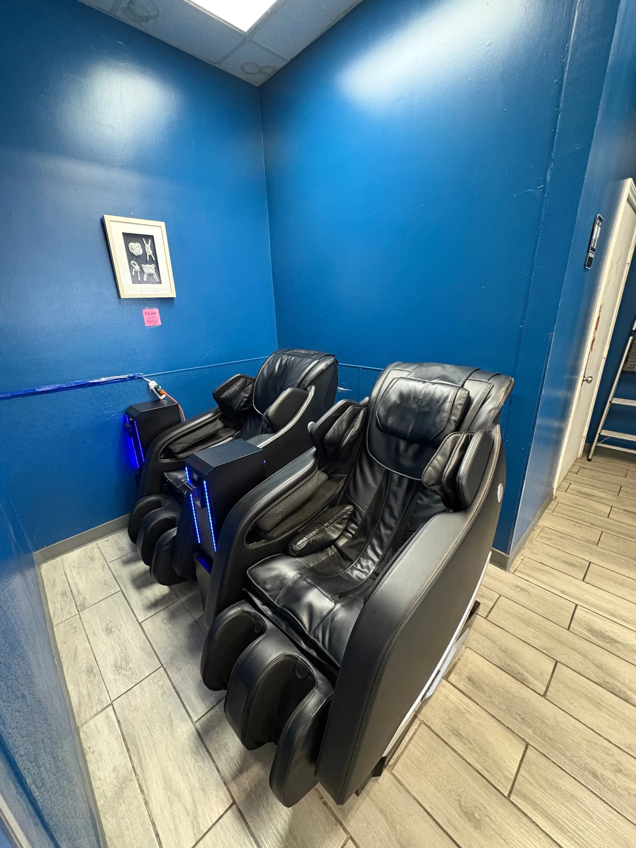 Relaxing black massage chairs inside the washateria lounge